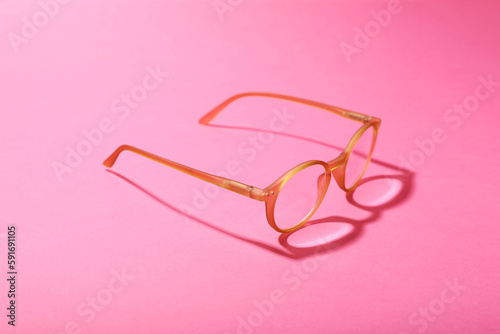Glasses with corrective lenses on bright pink background