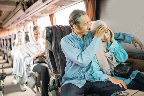 portrait of mature couple riding a bus, wife feeling tired and unwell