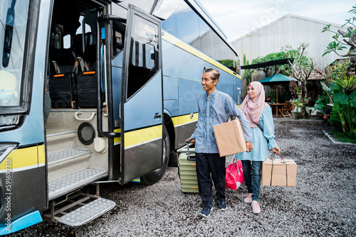 portrait of mature muslim passengers lined up in line to get on the bus