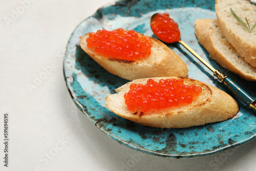 Tasty bruschettas with red caviar on white background