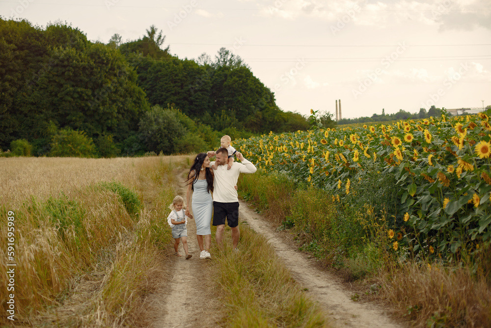 Beautiful family and child with sunflower in spring field