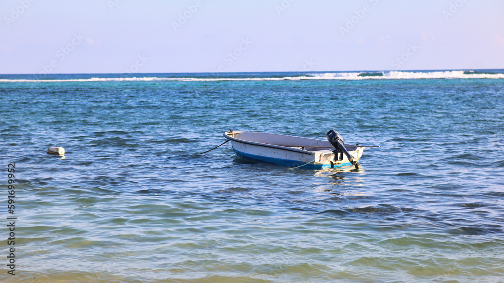 The natural beauty of the Eastern District, East End of the Cayman Islands, Grand Cayman, with fishing boat floating in the pristine beach with crystal-clear waters, a perfect tropical paradise 