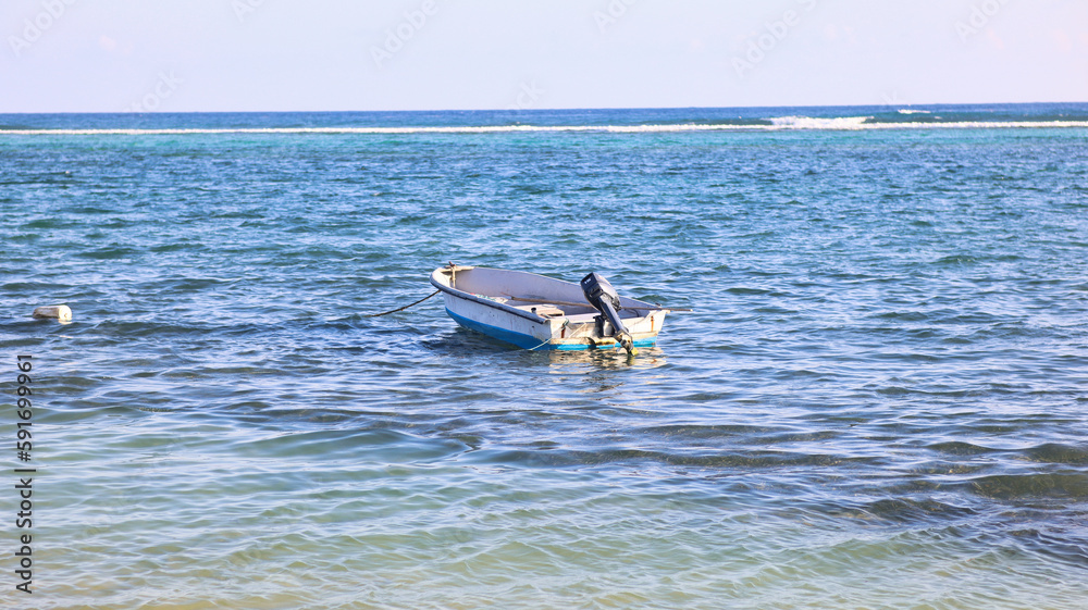Naklejka premium The natural beauty of the Eastern District, East End of the Cayman Islands, Grand Cayman, with fishing boat floating in the pristine beach with crystal-clear waters, a perfect tropical paradise 