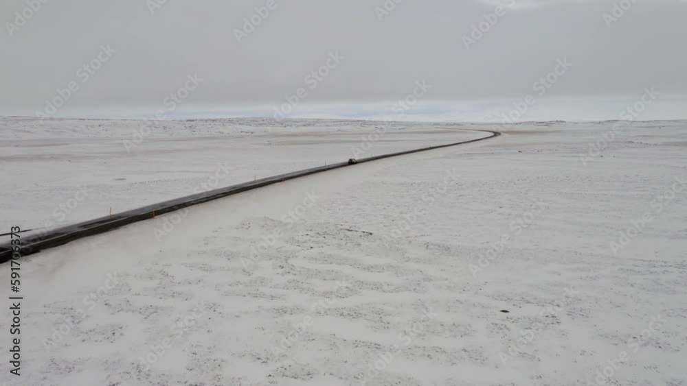 Aerial: Side follow of one car driving on snowy road Aerial: Side follow of one car driving on snowy road