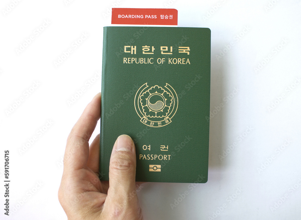 Republic of Korea passport and woman's hand with boarding pass isolated white background. Republic of Korea passport and woman's hand with boarding pass isolated white background.