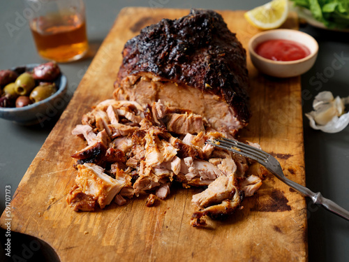 Pulled pork dinner served with sauces, roasted potatoes and salad