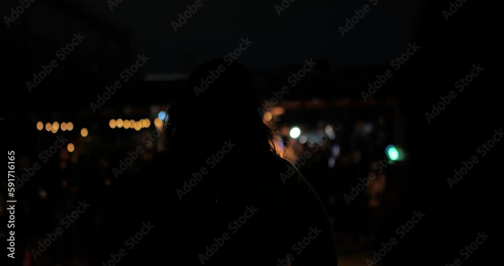 Woman looking at fire show back of woman