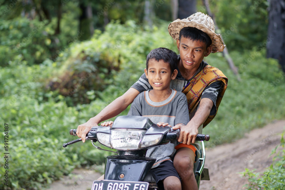 two village children riding an old motorcycle