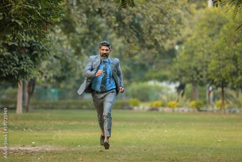 Indian corporate man running at park.