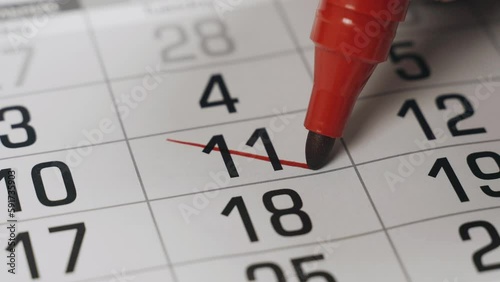 The eleventh in the calendar is boldly crossed out with a red marker as an important event completed. Close-up.