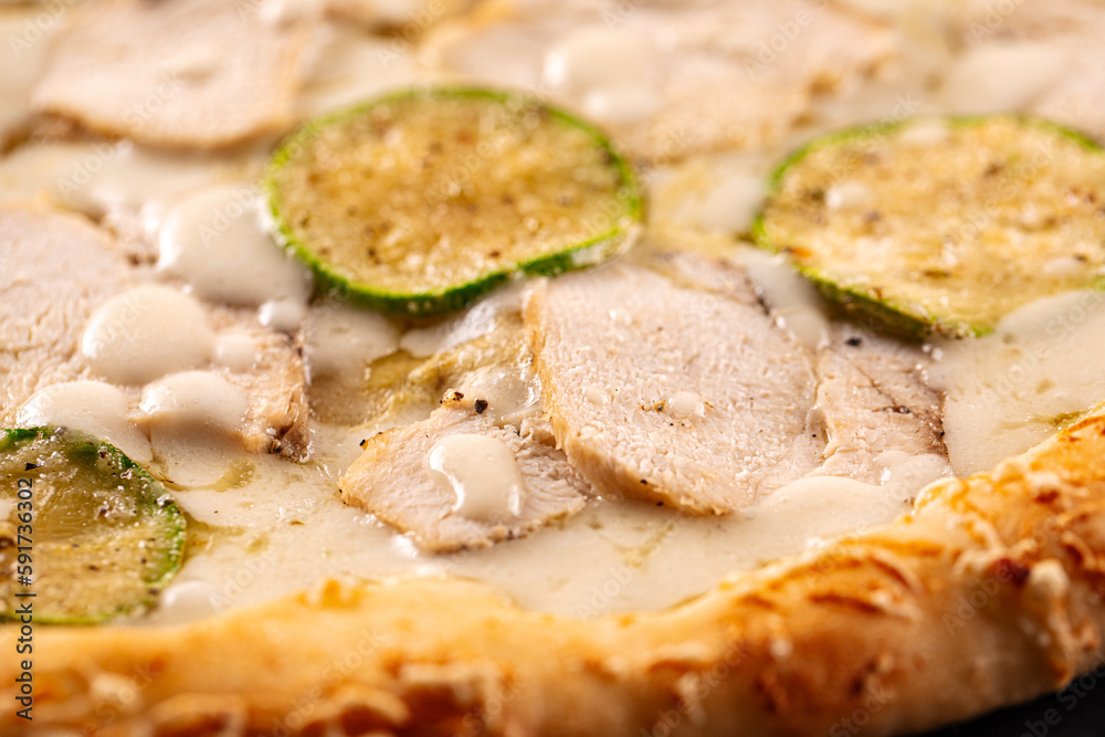 Closeup on chicken pizza with zucchini and cheese