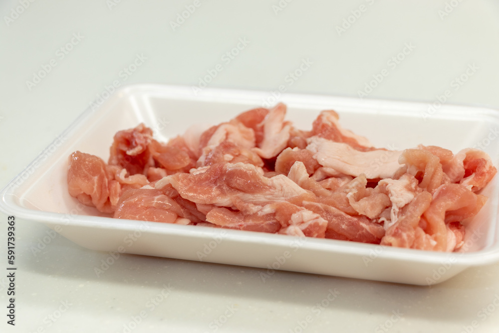 白いプラスチックトレイの上の赤い豚肉
