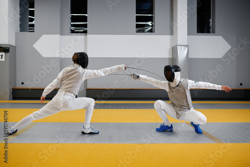 Duel of fencers during fencing match, training lesson at martial art class