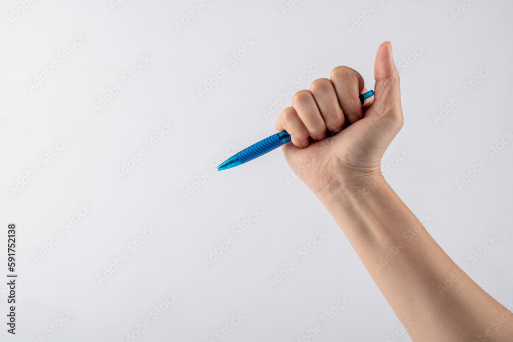 Close-up of a woman's hand holding a pen and writing gesture isolated on a white background