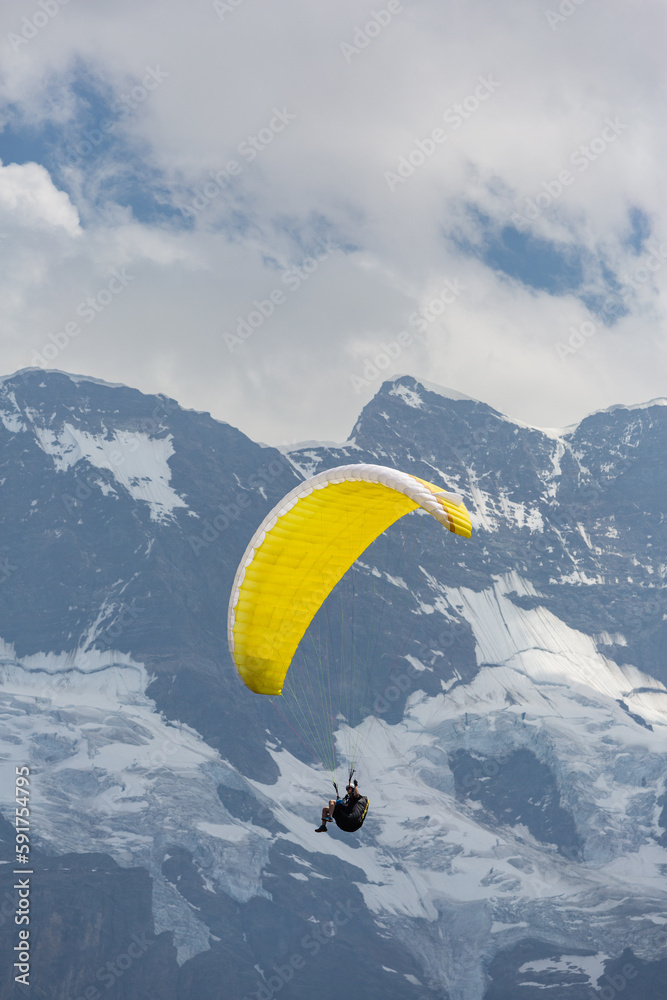 Paragliding in the Swiss Alps as captured from the town of Murren, nestled below the Schilthorn mountain peak Paragliding in the Swiss Alps as captured from the town of Murren, nestled below the Schilthorn mountain peak