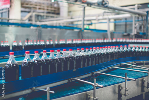 Beverage factory interior. Conveyor flowing with bottles.