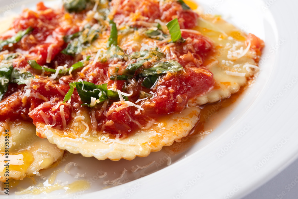 Piatto di deliziosi ravioli al pomodoro e basilico con una spolverata di parmigiano, cibo italiano Piatto di deliziosi ravioli al pomodoro e basilico con una spolverata di parmigiano, cibo italiano