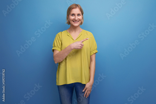 middle aged woman with insight points finger to the side in studio