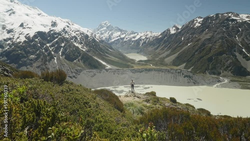 Woman on Sealy Tarns Trail with view of Mueller Lake and Mount Cook, NZ photo