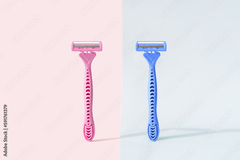 Razors with gender colors against pink and blue background.