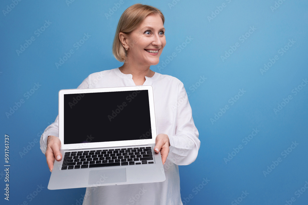 portrait of happy middle aged business woman with blond hair using laptop with mocup portrait of happy middle aged business woman with blond hair using laptop with mocup