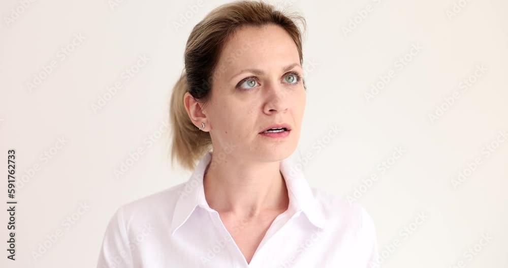 Suspicious woman turns head to sides opening eyes broadly on beige background. Nervous female person examines new area slow motion Suspicious woman turns head to sides opening eyes broadly on beige background. Nervous female person examines new area slow motion