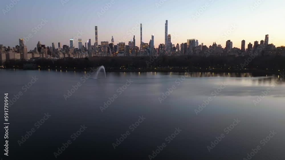 Aerial view tilting over Central Park Reservoir, towards the Midtown skyline, dusk in NY, USA Aerial view tilting over Central Park Reservoir, towards the Midtown skyline, dusk in NY, USA