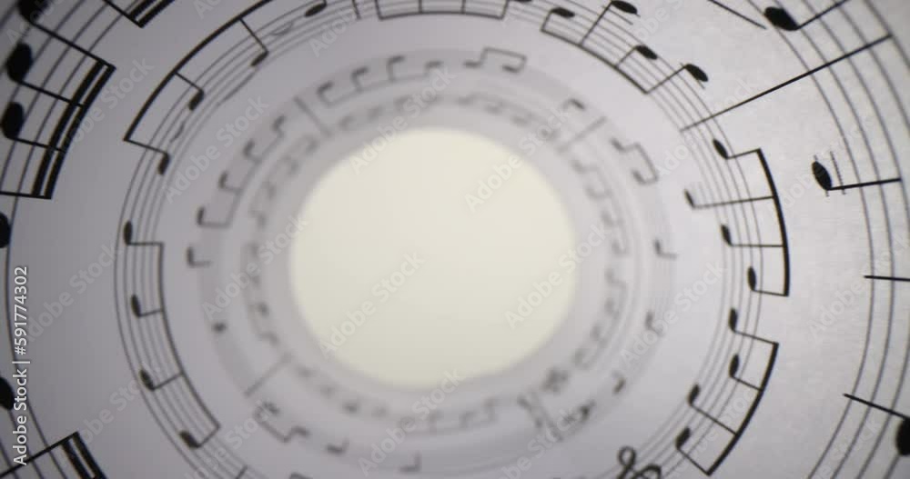 Twisted in pipe manuscript with staves ready for musical notation. Roll of music paper with lines and notes stands on white table making hole Twisted in pipe manuscript with staves ready for musical notation. Roll of music paper with lines and notes stands on white table making hole