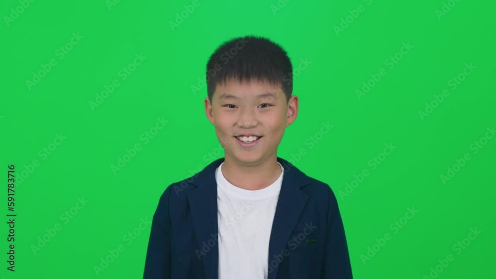 Chromakey template, portrait of a cheerful Asian boy looking into the camera on a green background. Chromakey template, portrait of a cheerful Asian boy looking into the camera on a green background.
