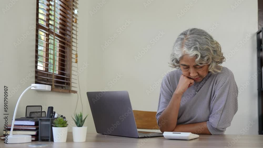 Older woman calculates, writes, pay bills on-line, prepare financial report working from home. Focused mature female, doing accountancy job busy in finances control Older woman calculates, writes, pay bills on-line, prepare financial report working from home. Focused mature female, doing accountancy job busy in finances control