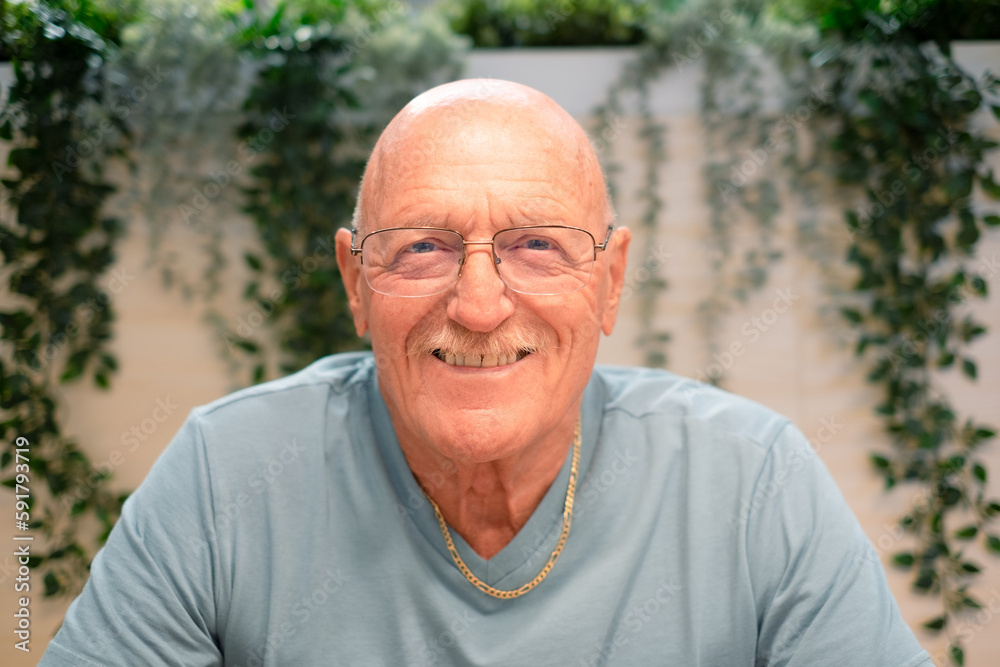 Close-up Portrait of Happy 70 Years Old Senior Man Smiling Looking at Camera. Relaxed Grandfather in Casual Clothing and Eyeglasses