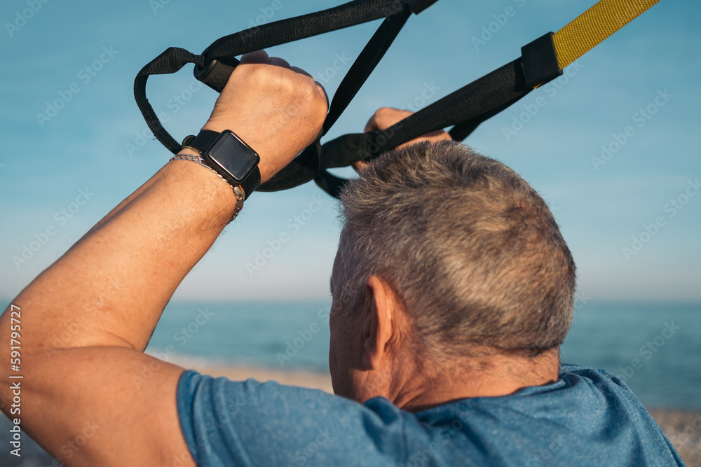 Rear closeup image of an older whitehaired person performing