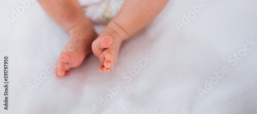 Newborn baby feet on white blanket. Cmaternity and babyhood concept.