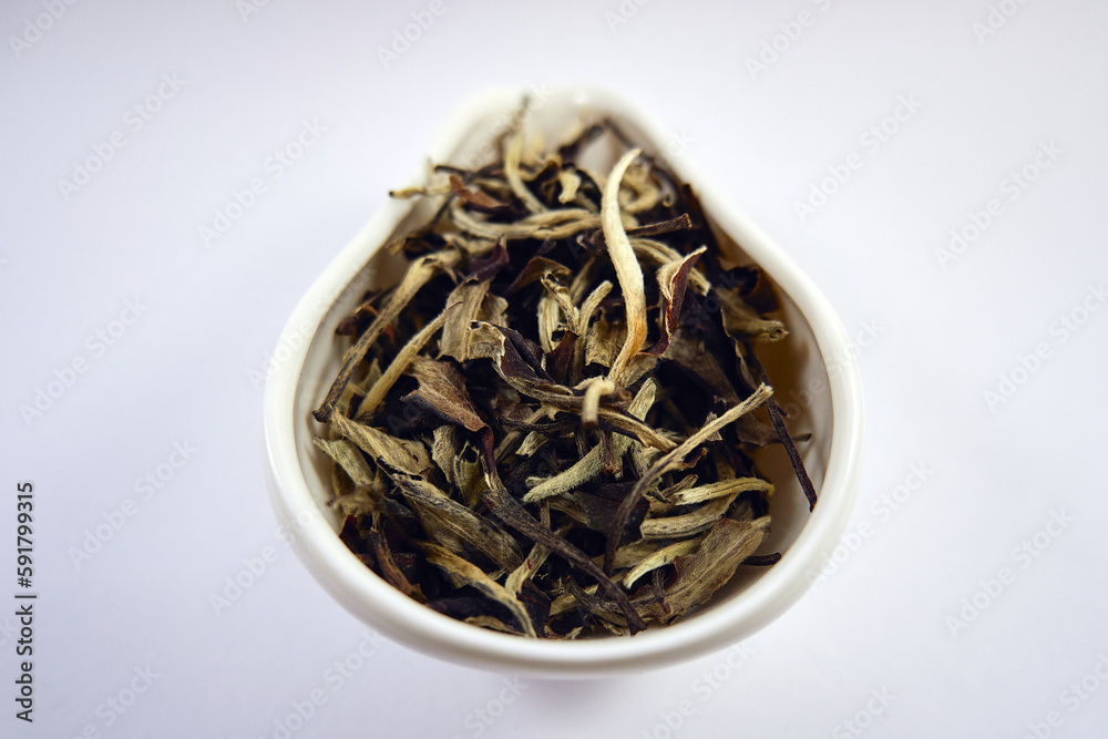 Fototapeta premium Dry Chinese white tea in a white porcelain bowl close-up