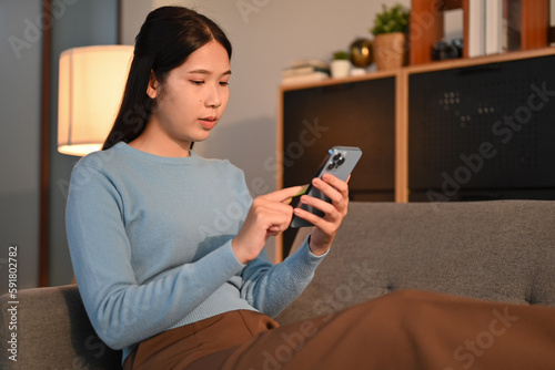 Young woman checking social media or chatting with friens on her mobile phone. People, technology and lifestyle concept photo