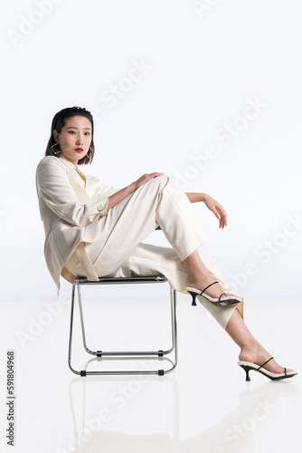 Fashionable young woman posing on chair