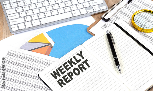 WEEKLY REPORT text on notebook with chart and keyboard