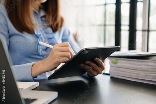 Businesswoman working with VR wide blank screen tablet  computer and smart phone on office blur background.