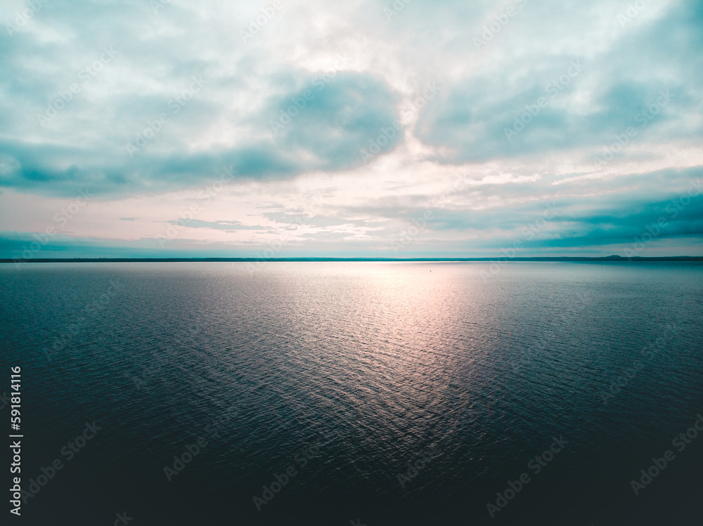 Breathtaking scenery of a dark mysterious lake under a cloudy sky in sunset