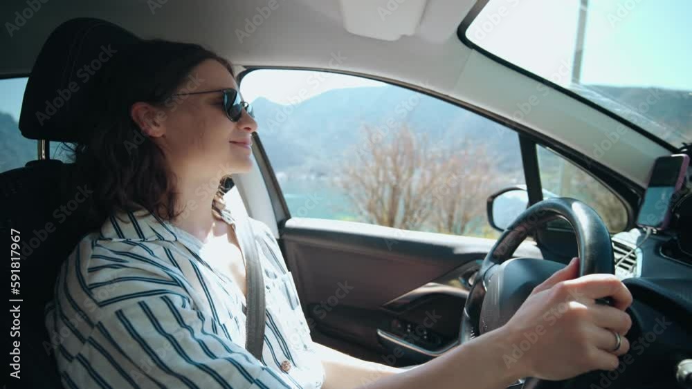 A young caucasian woman driving a car during her vacation to the sea. A young caucasian woman driving a car during her vacation to the sea.