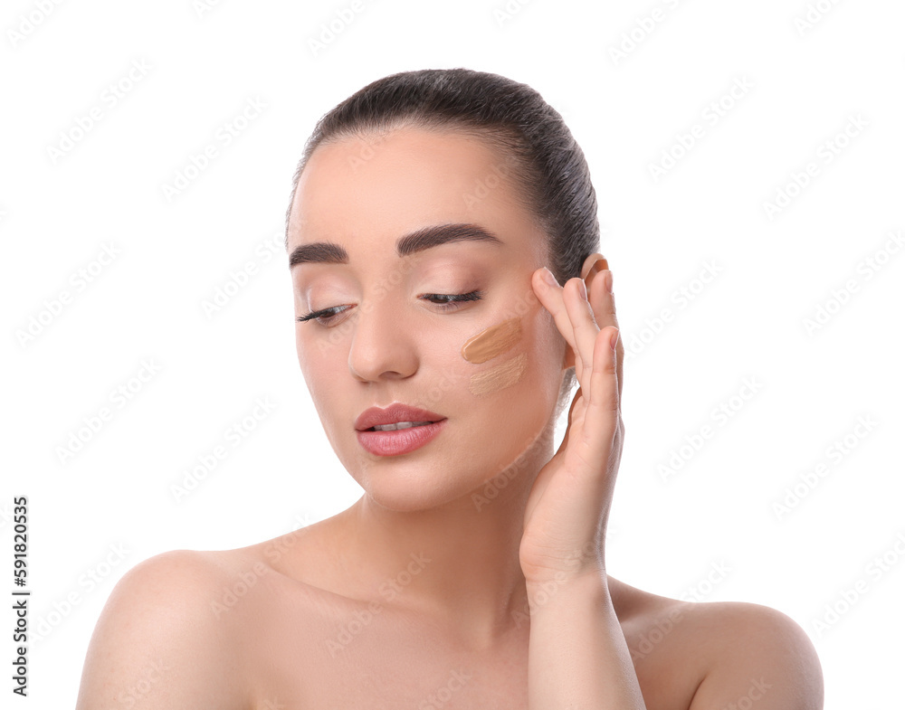 Woman with swatches of foundation on face against white background