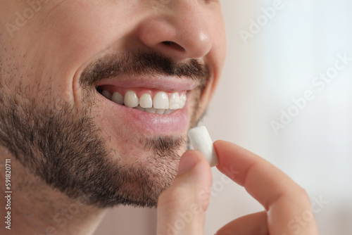 Photos Man with chewing gum on blurred background, closeup