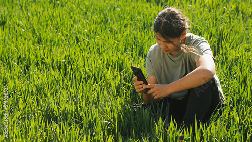 Girl on a meadow with a mobile. photo