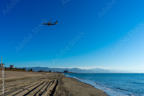 Airplane landing at sunrise over Mediterranean Sea, Costa del Sol in Malaga, Spain on March 25, 2023