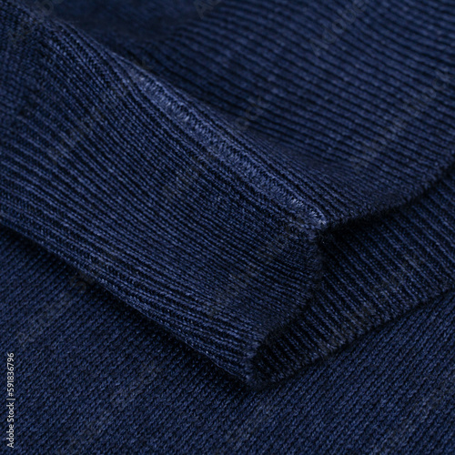 Knitted elastic band on navy blue wool jumper close up