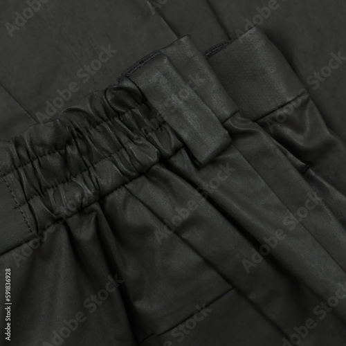Detail of a khaki waxed trouser belt with loop and pocket