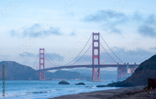 Golden Gate Bridge and the bay with mountains in the background on a foggy day