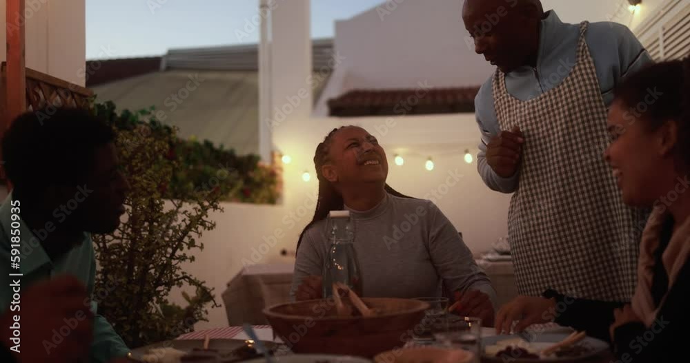 African family cooking dinner and eating healthy food at home patio - Lifestyle home moments and summer concept