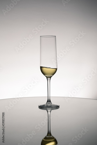 Glass of white wine with the reflection on table