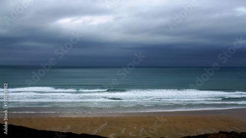 Fototapeta Naklejka Na Ścianę i Meble -  Beautiful view of sea waves on a beach with a storm brewing on the horizon